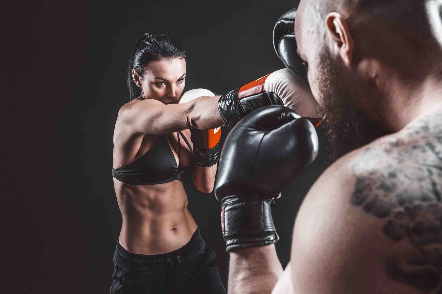 Loveless Academy of Karate & Kobudo, Woman exercising with trainer at boxing and self-defense lesson